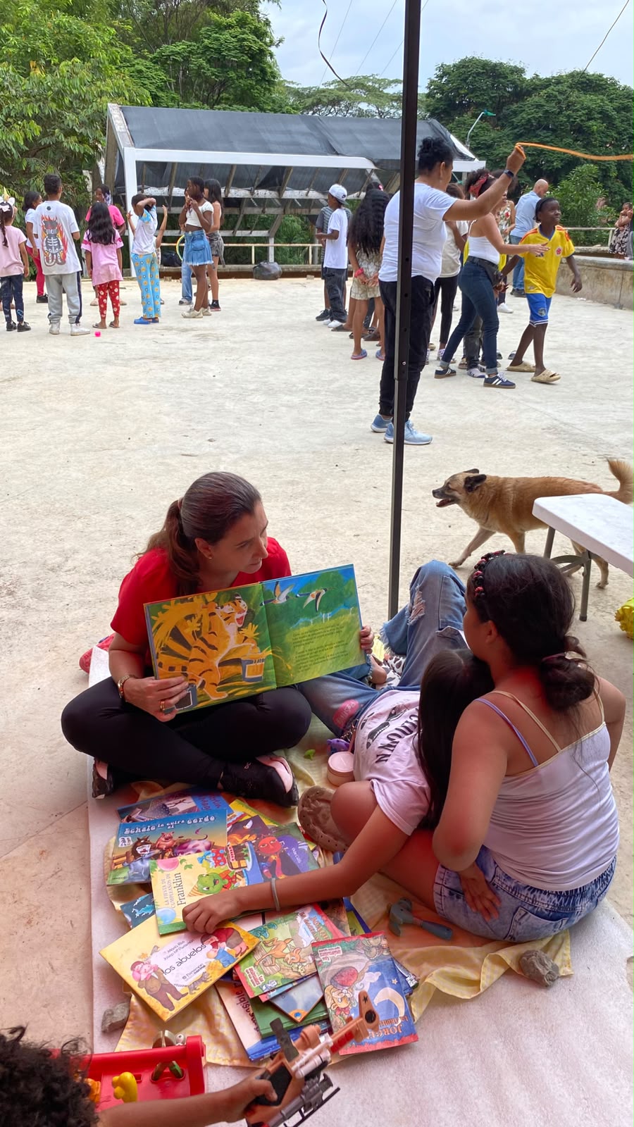 Dos niñas leen cuentos infantiles sentadas en el suelo junto a la colección de libros